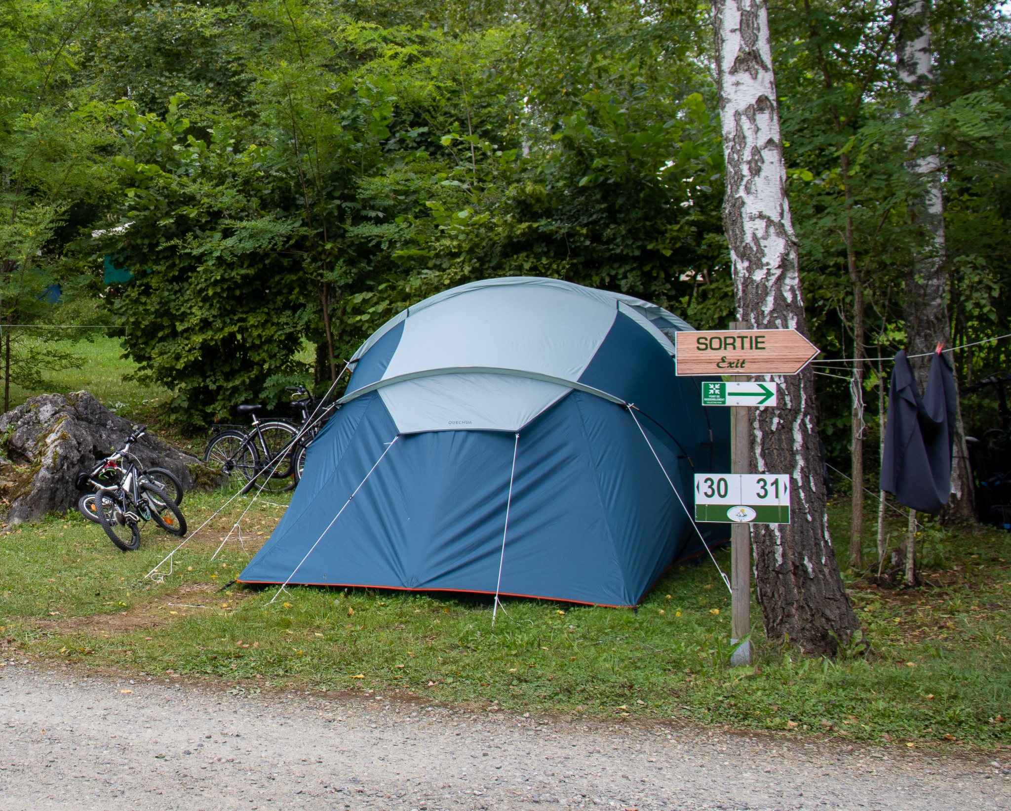 Tente installée sur un emplacement nature ombragé, avec vélos à proximité, au Camping Parc d’Audinac les Bains en Ariège