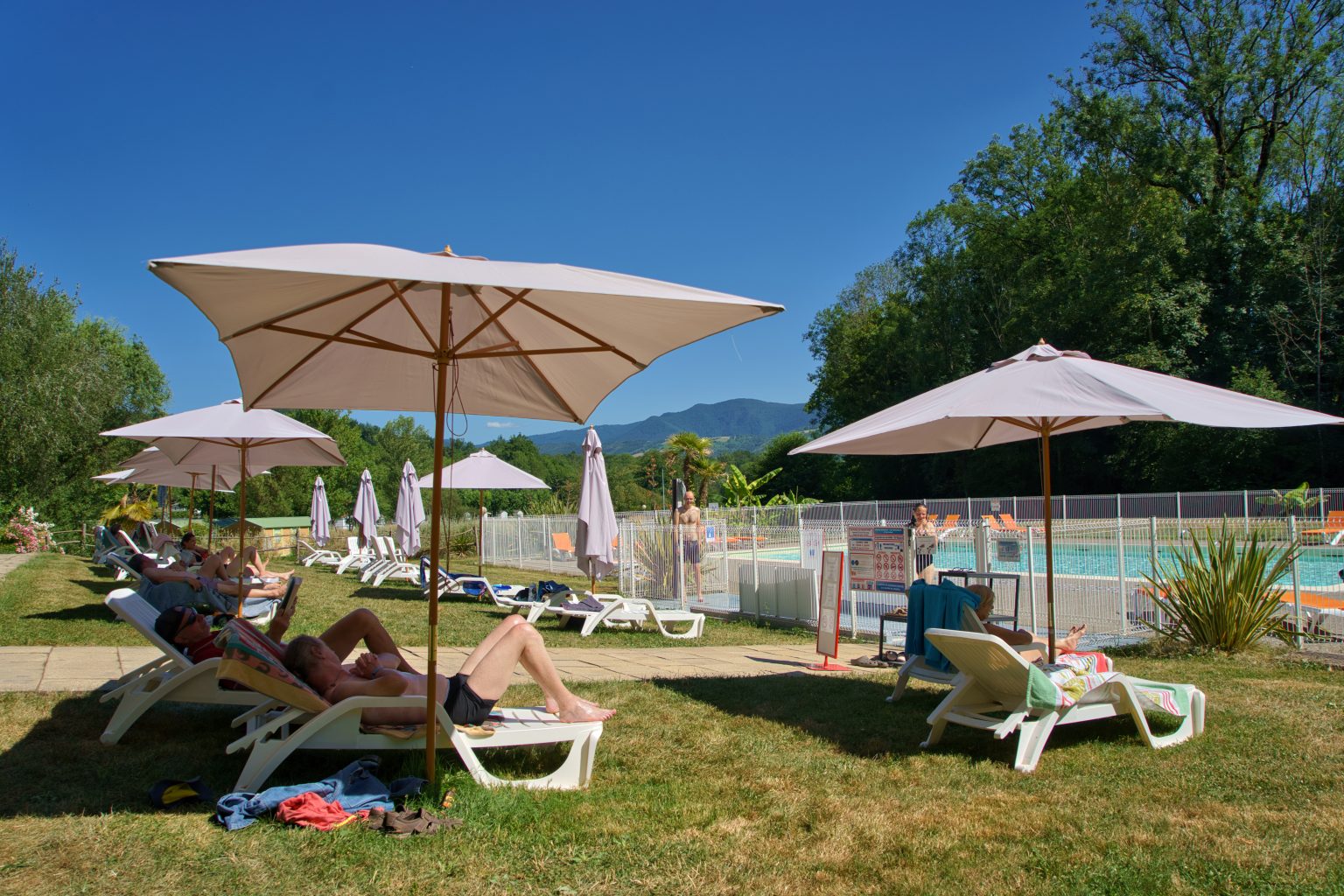 Vacanciers profitant de la piscine du Camping Parc Audinac-les-Bains, au cœur des montagnes de l’Ariège