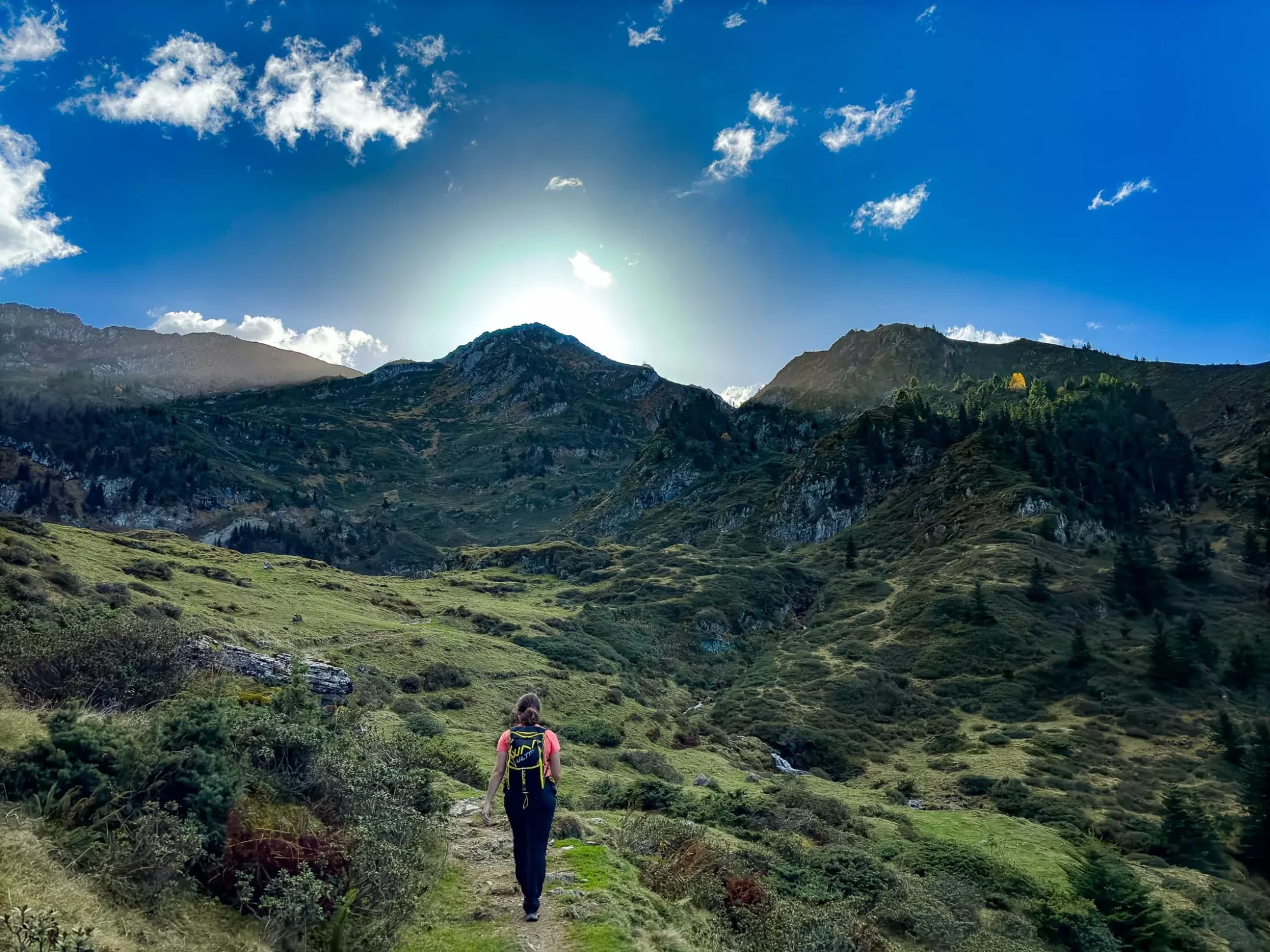Randonneuse sur sentier vallée verdoyante Pyrénées Ariège Couserans camping Audinac