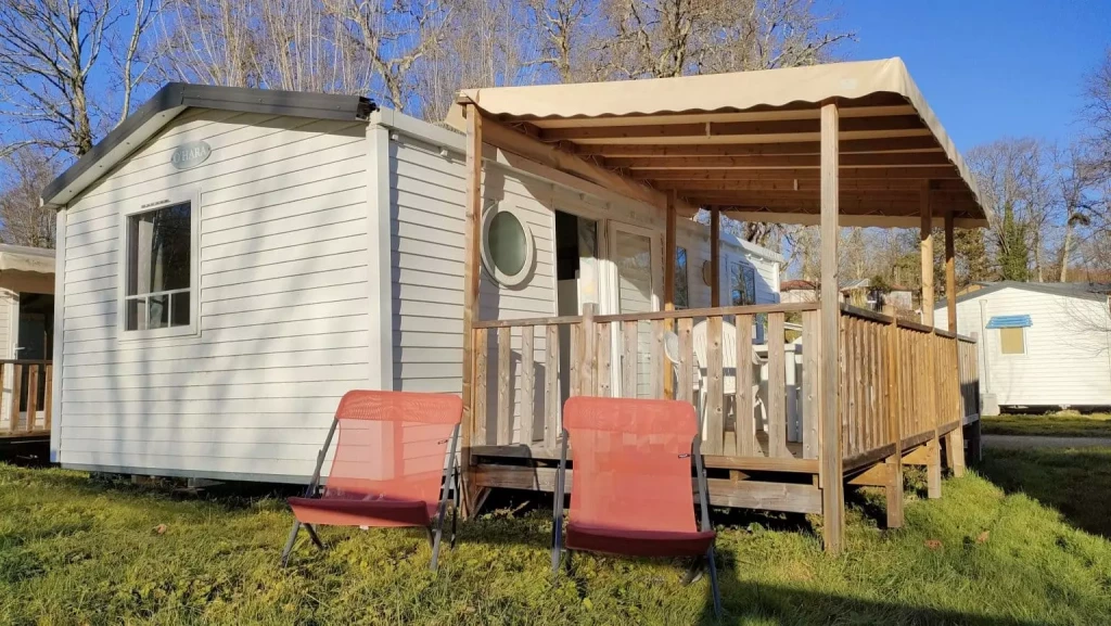 Mobil-home 3 chambres climatisé O'Hara avec terrasse couverte en bois et transats au Camping Audinac les Bains en Ariège