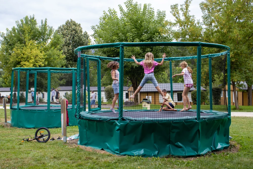 Les enfants s’amusent sur les trampolines du camping